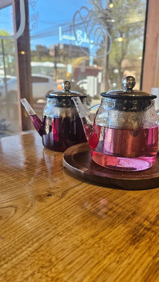 Dos teteras de vidrio con té de frutas servidas en Lucca
